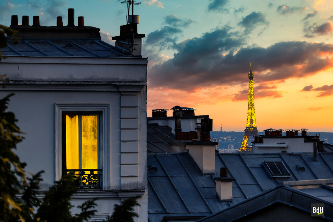 La Tour Eiffel éclairée à la tombée de la nuit depuis Montmartre à Paris, France