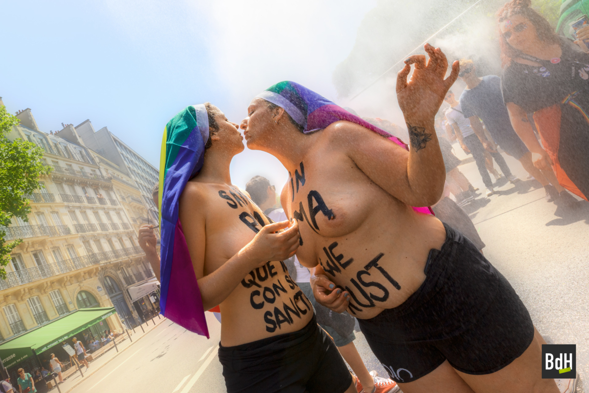 Deux femmes militant pour la PMA seins nus s'embrassent à La Marche des Fiertés (Gay Pride) lors de la canicule à 38°c le 29 Juin 2019 à Paris, France.